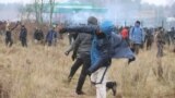 BELARUS -- Migrant crisis on the Belarusian-Polish border -- A man throws a stone in the direction of a border fence and Polish law enforcement officers, as migrants attempt to cross the Belarusian-Polish border at Bruzgi - Kuznica checkpoint in the Grodn
