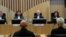 NETHERLANDS -- Presiding judge Hendrik Steenhuis, rear second from right, waits for Ria van der Steen, who lost her father and stepmother in the MH17 crash, right, to give testimony in court in the trial of four men charged with murder over the downing of