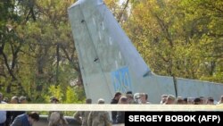 Эксперты и военные работают на месте авиакатастрофы Ан-26 в Харьковской области. Фото: AFP