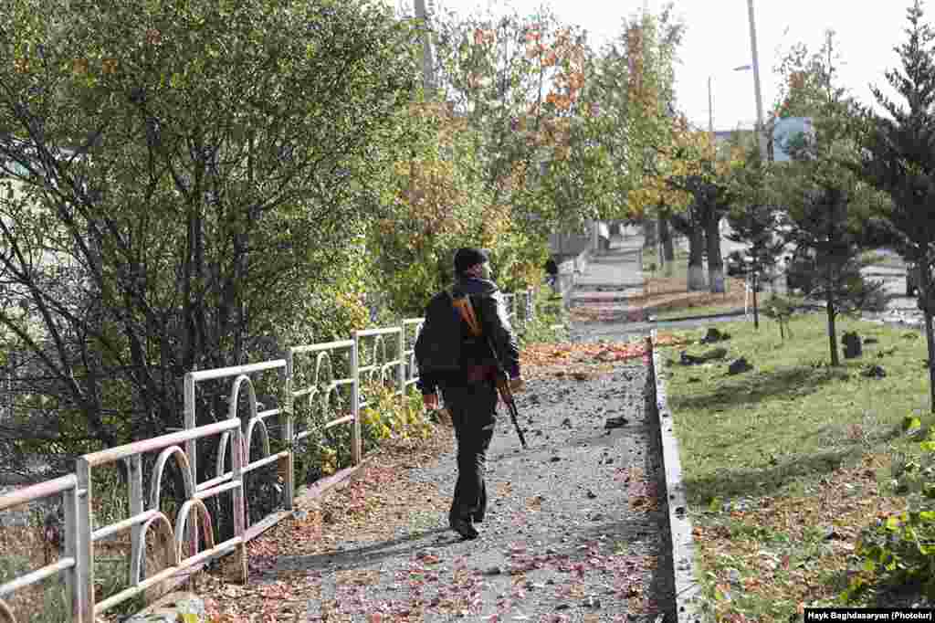 An armed man walks along a street in Shushi (Shusha) a few days before de facto Nagorno-Karabakh leader Arayik&nbsp;Harutiunian announced on October 29, 2020 that Azerbaijani forces were 5 kilometers away from the town.&nbsp;