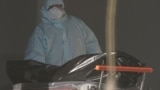 RUSSIA -- A medical specialist wearing protective gear pushes a stretcher while relocating a non-transparent bag, which presumably contains a human body, in a hospital for patients infected with the coronavirus disease (COVID-19) on the outskirts of Mosco