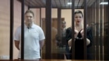 BELARUS -- Belarusian opposition figures Maryya Kalesnikava and Maksim Znak, charged with extremism and trying to seize power illegally, stand inside a defendants' cage as they attend a court hearing in Minsk, September 6, 2021