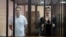 BELARUS -- Belarusian opposition figures Maryya Kalesnikava and Maksim Znak, charged with extremism and trying to seize power illegally, stand inside a defendants' cage as they attend a court hearing in Minsk, September 6, 2021