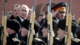 RUSSIA -- Russian President Vladimir Putin (L) and Defence Minister Sergei Shoigu watch honour guards passing by as they take part in a wreath-laying ceremony marking the Defender of the Fatherland Day at the Tomb of the Unknown Soldier by the Kremlin wal