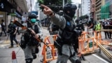 Riot police clear up debris left by protesters in Hong Kong