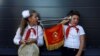 RUSSIA -- A boy and a girl wearing red neckerchiefs, the symbol of the Young Pioneer Soviet-era organisation, play with a horn during a ceremony opening a Russian history interactive museum in Pyatigorsk, September 11, 2020