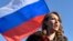 RUSSIA -- (FILES) In this file photo taken on February 27, 2018 Russian presidential candidate Ksenia Sobchak speaks next to a Russian flag in central Moscow at the site where late opposition leader Boris Nemtsov was fatally shot on a bridge near the Krem