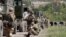 Service members of pro-Russian troops stand guard in Mariupol