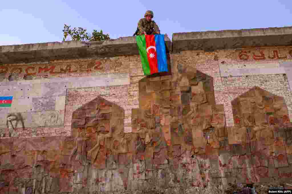 NAGORNO KARABAKH -- An Azeri soldier hangs the flag of Azerbaijan in the city of Jabrayil, where Azeri forces regained control during the fighting with Armenia over the breakaway region of Nagorno-Karabakh on October 16, 2020.