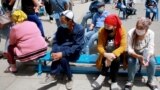 Bishkek residents wait for their turn to receive medical care near a day hospital in the Kyrgyz capital on July 6, 2020.