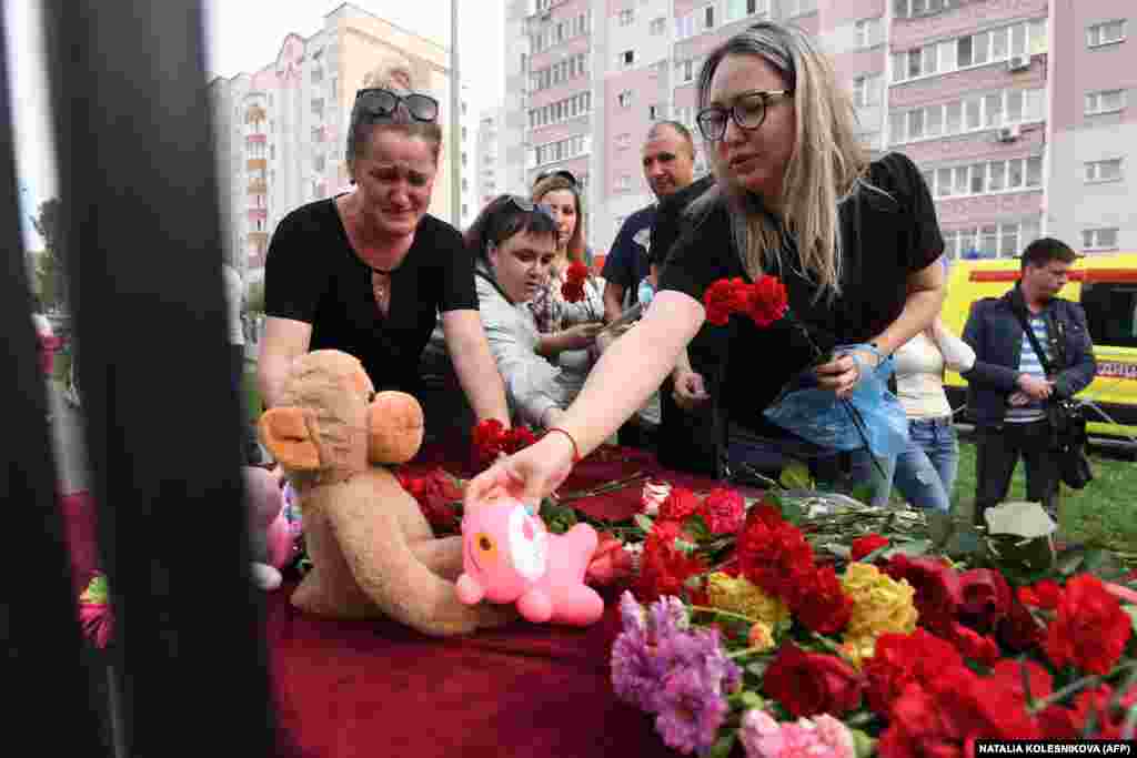 A woman places a toy at a makeshift memorial for victims of the shooting at School No. 175 in Kazan, the regional capital of Russia&#39;s republic of Tatarstan, on May 11, 2021.