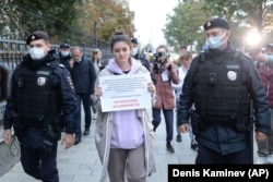 Полицейские задерживают Алесю Мароховскую во время пикета возле здания Минюста 8 сентября 2021 года. Надпись на плакате: "Нет иноагентов, есть журналисты!" Фото: AP