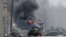 UKRAINE – This photograph taken on February 27, 2022 shows a Russian Armoured personnel carrier (APC) burning next to unidentified soldier's body during fight with the Ukrainian armed forces in Kharkiv