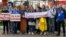 BELARUS -- Journalists of Belarusian TUT.BY media outlet hold banners reading "I don't protest but work", "This is me at work", "Freedom for journalists!", from left to right, as they stand in front of police station in Minsk, September 2, 2020