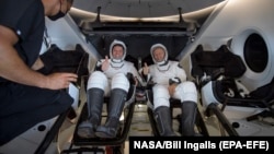 Астронавты Дуглас Херли и Роберт Бенкен на борту Crew Dragon после возвращения на Землю 2 августа.