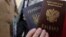 UKRAINE – A woman poses with a Ukrainian and a Russian passport outside an office of the Russian Federal Migration Service, where she received a Russian passport, in the Crimean city of Simferopol, April 7, 2014