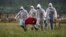 Virus Outbreak Russia -- file -- Cemetery workers wearing protective suits carry the coffin of a COVID-19 victim in the special purpose for coronavirus victims section of a cemetery in Kolpino, outside St.Petersburg, Russia, Tuesday, June 30, 2020. 