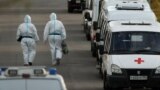 Medical specialists wearing protective gear walk past ambulances outside a hospital for patients infected with the coronavirus disease (COVID-19) on the outskirts of Moscow, Russia October 15, 2020. REUTERS/Maxim Shemetov