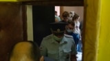 Полицейские покидают квартиру журналистки "Проекта" Марии Жолобовой после обыска, 29 июня 2021 года. Фото: AP