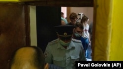 Полицейские покидают квартиру журналистки "Проекта" Марии Жолобовой после обыска, 29 июня 2021 года. Фото: AP