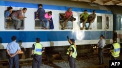 Полиция Словении охраняет поезд с беженцами неподалеку от границы с Хорватией, сентябрь 2015 года