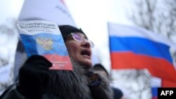 A woman with a copy of the Russian constitution takes part in a February 29, 2020 march in memory of murdered Kremlin critic Boris Nemtsov in downtown Moscow.