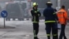 A firefighter talks on the phone as fire engines are lined up after a fire broke out at metal factory in Berlin