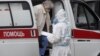 RUSSIA - A medical specialist in a protective suit escorts a patient to the hospital complex for patients with the COVID-19 disease in the Kommunarka settlement in New Moscow, Russia, 14 July 2020