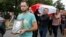 BELARUS -- People carry the coffin and a portrait of Mikita Kryutsov as they attend his funeral in the town of Molodechno, 70 km (46 miles) north-west of Minsk Molodechno, August 25, 2020