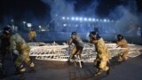 KYRGYZSTAN -- Law enforcement officers remove a barricade set up by protesters during a rally against the results of a parliamentary vote in Bishkek on October 5, 2020.