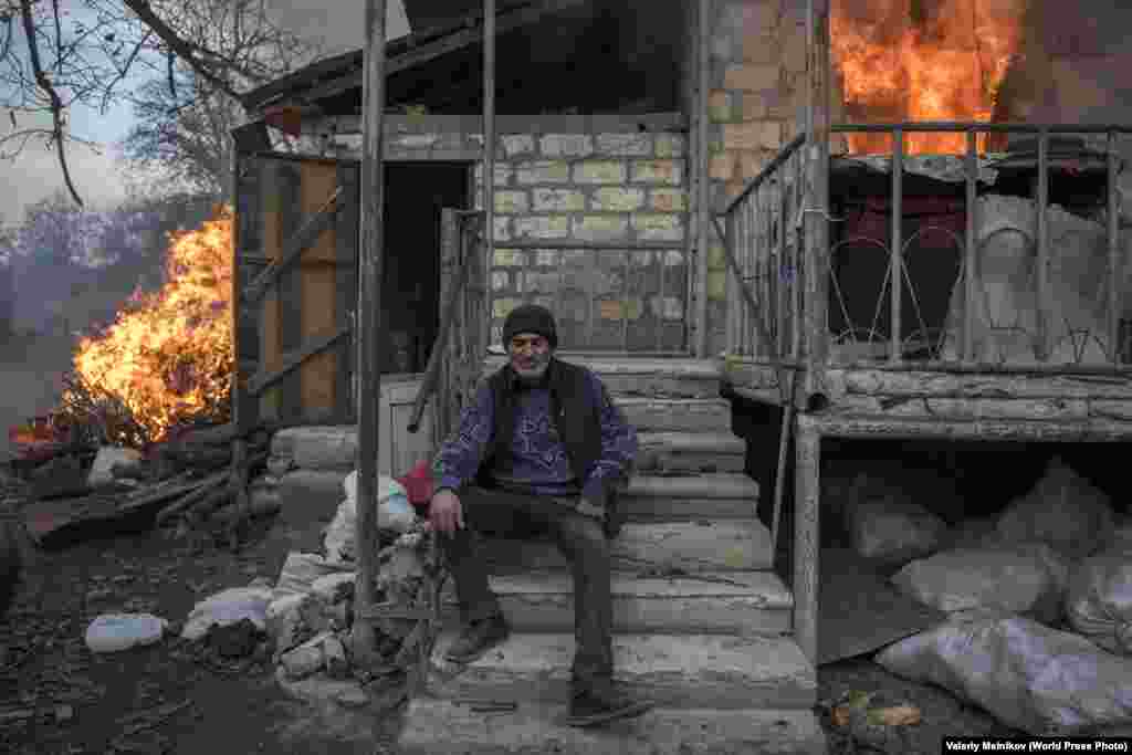 Арег на крыльце горящего дома в Нагорном Карабахе (25 ноября 2020). Некоторые жители сжигали свои дома до того, как эти территории переходили под контроль Азербайджана после подписания мирного соглашения в ноябре. Первое место в категории&nbsp;&quot;Новости&quot;, автор &ndash; Валерий Мельников
