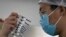 CHINA -- A worker inspects syringes of a vaccine for COVID-19 produced by Sinovac at its factory in Beijing, September 24, 2020
