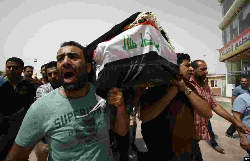 Иракцы несут гроб в городе Наджаф во время траурной процессии по жертвам взрывов смертников в Багдаде (AFP/Haidar Hamdani)