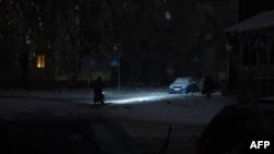 Житель Киева едет на велосипеде по темной после российского удара и отключения электроснабжения улицк. 9 января 2026 года. Фото: AFP