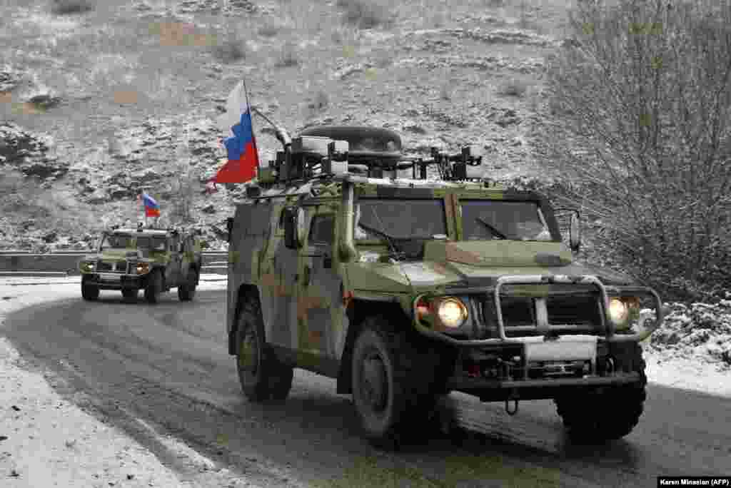 Military vehicles used by Russian peacekeepers travel a road outside of the town of Lachin (Berdzor) on November 29, 2020. Under the ceasefire deal with Armenia and Azerbaijan, Russian peacekeepers will be stationed along the so-called Lachin Corridor, a roughly 80-kilometer-long road that connects breakaway Nagorno-Karabakh with Armenia.&nbsp;