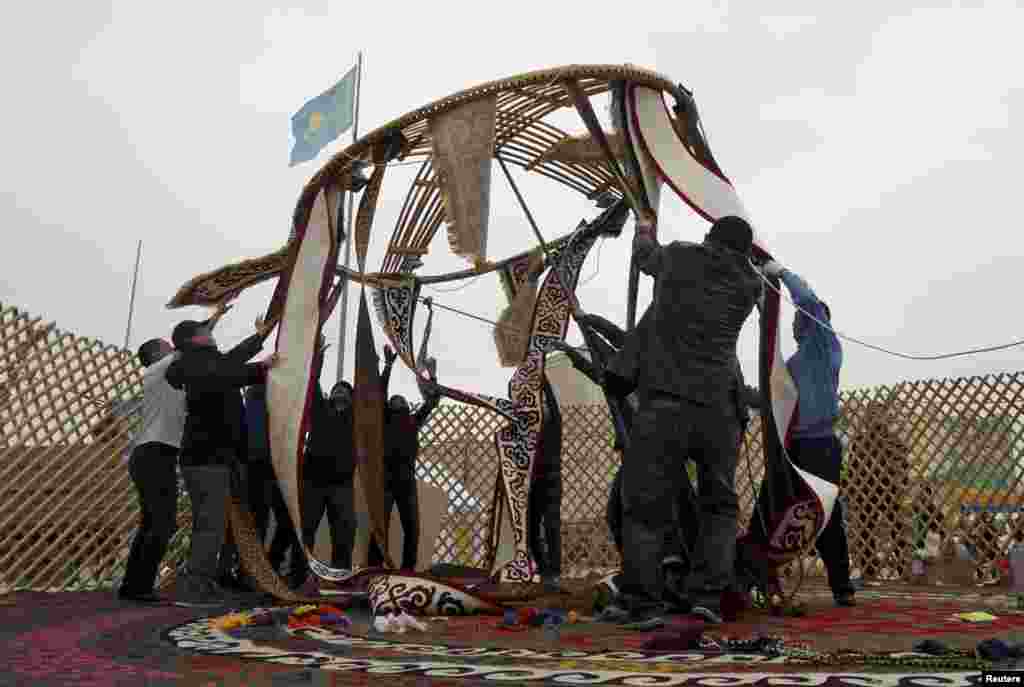 Мужчины разбирают юрту, поставленную к празднованию Навруза. Казахстан