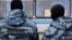 Russia - Migrant worker looks out of a police vehicle, OMON