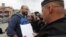 Полицейский зачитывает постановление муниципальному депутату Илье Азару 