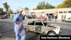 Следователь возле сгоревшей машины в городе Барда