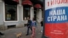 RUSSIA -- People walk with a dog past a billboard advertising on a nationwide vote on constitution changes, in St. Petersburg, June 11, 2020