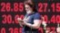 UKRAINE -- A woman walks past a board showing currency exchange rates in Kyiv, Ukraine July 2, 2020
