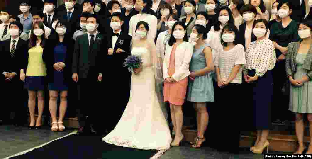 На фото - свадебная церемония в масках. Пара стала негласным символом южнокорейской эпидемии