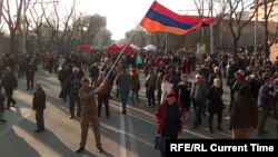 A protester waves the Armenian flag in downtown Yerevan on March 1 at ongoing demonstrations for Armenian Prime Minister Nikol Pashinian's resignation. 