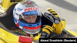 Премьер-министр России Владимир Путин сидит в автомобиле команды Renault Formula One перед тестовой поездкой на гоночной трассе в Ленинградской области, 7 ноября 2010 года. Фото REUTERS/РИА Новости