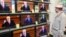 BELARU -- A costumer in a electronics shop watches Belarusian President Alyaksandr Lukashenka on the TV screens delivering his annual state-of-the-nation address, in MInsk, December 3, 2015