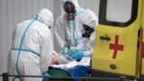 RUSSIA -- Emergency doctors wearing protective equipment transport a man to a hospital for COVID-19 patients in St. Petersburg, May 19, 2020